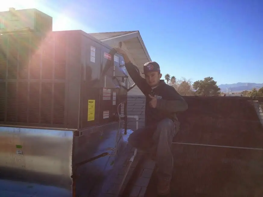 HVAC technician performing HVAC Inspection on a rooftop unit in Menomonie
